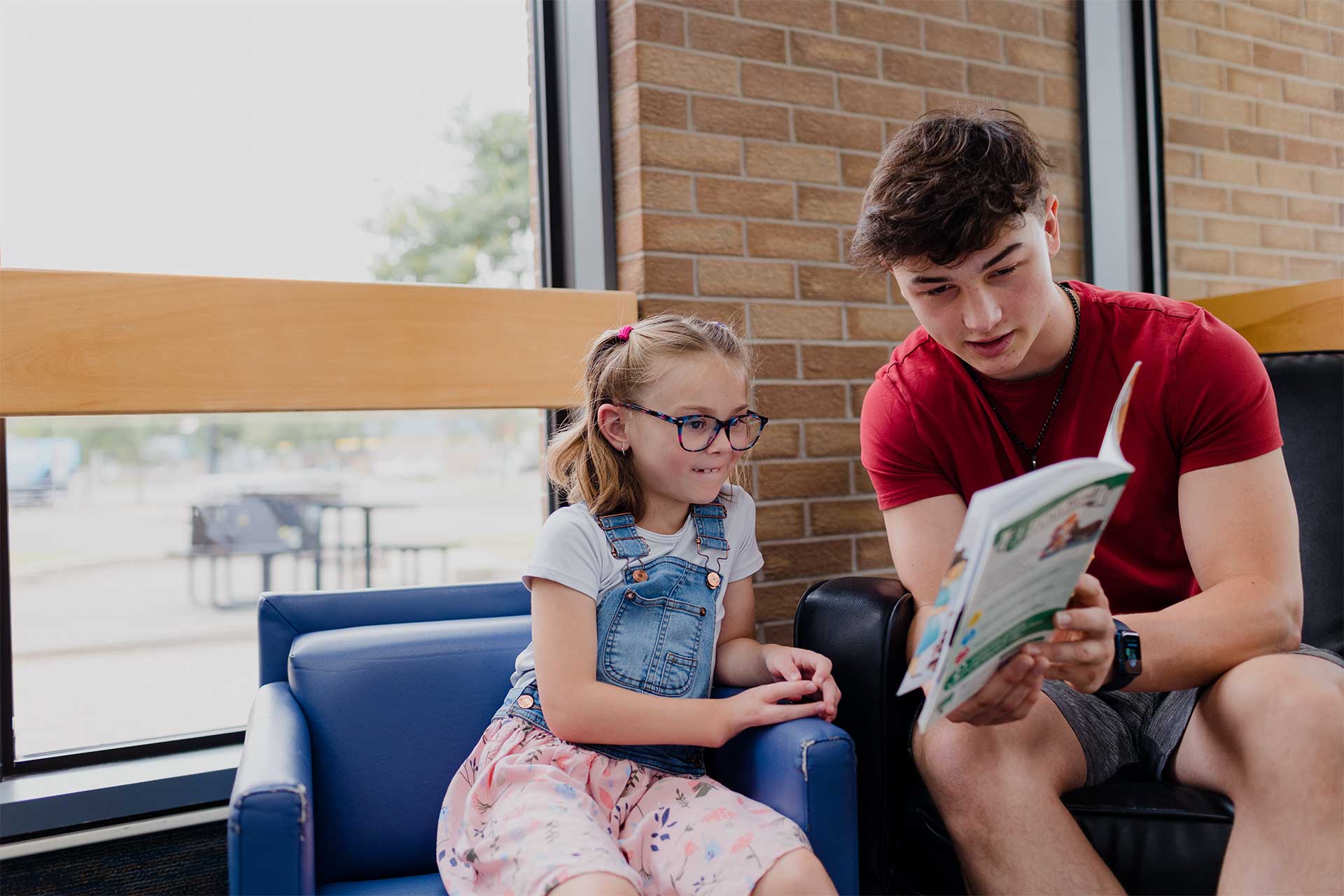 Youth Reading Books in Regina Public Library sitting area